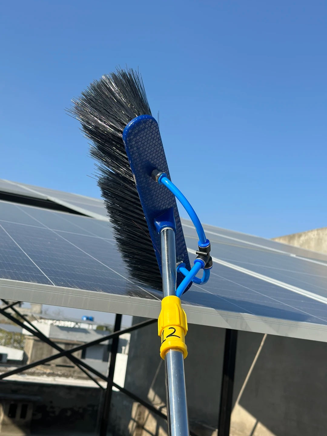 Close-up of solar panel cleaning brush head and water tube