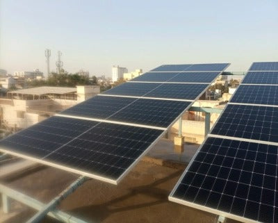 Solar panels being washed with extendable cleaning brush